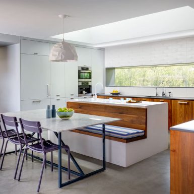 Ranch Redux - Interior view of modern, light-filled kitchen with long countertop window and skylight. Photograph by Trevor Tondro.